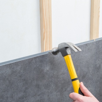 Dumawall wandpaneel dat met nagels op een houten regelwerk wordt bevestigd.